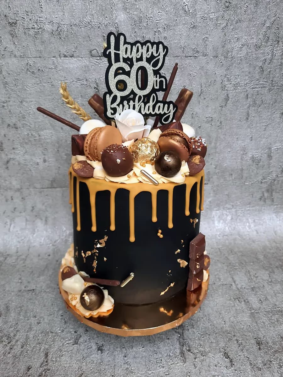Black and gold drip 60th birthday cake with macarons and chocolates