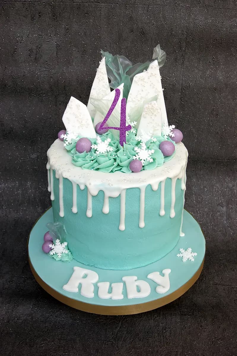 Frozen themed 4th birthday cake in teal and white with a drip and number topper