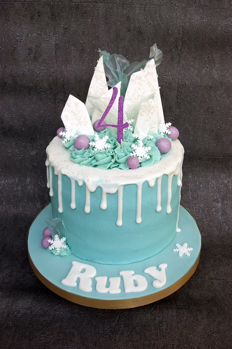 Frozen themed 4th birthday cake in teal and white with a drip and number topper