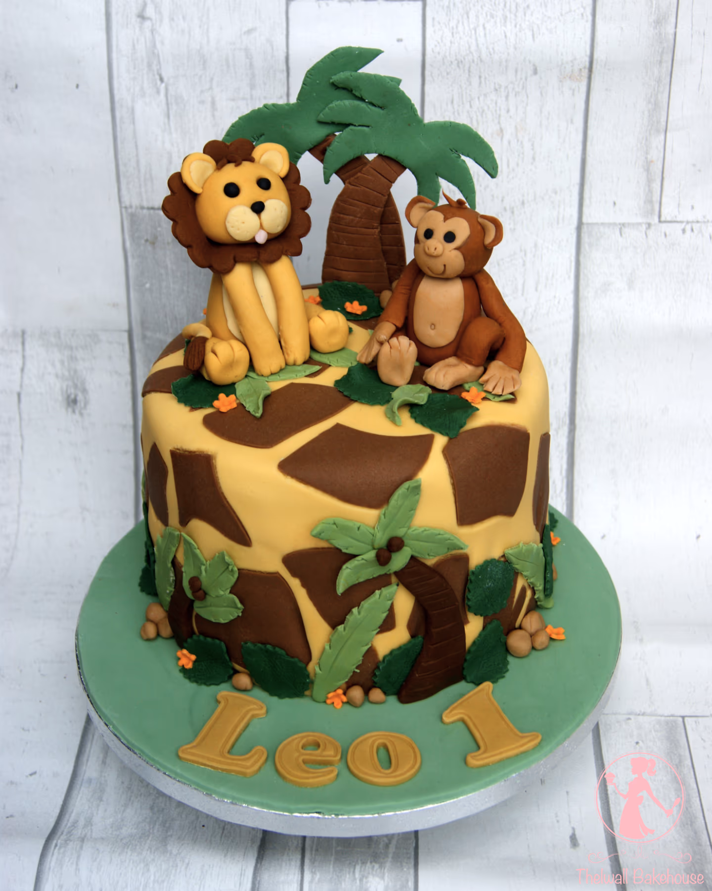 Safari themed first birthday cake with lion, monkey, and giraffe print